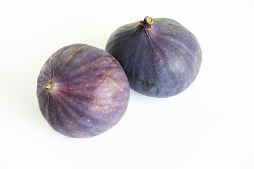 two fresh whole figs over a white background