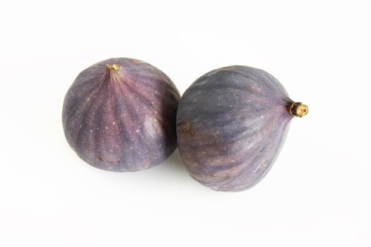 two whole fresh figs over a white background