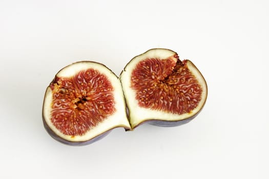 one single fig cut in half showing the seeds inside