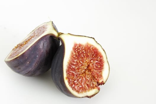 one single fig cut in half showing the seeds inside