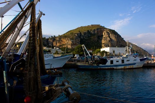 Italian harbor with fishing boats and old temple on background