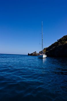 Sail yacht at anchor on the blue sky near Ponza island (Italy).