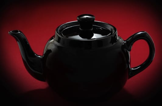 red teapot over red background