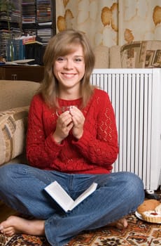 Woman sits on a carpet in a living room