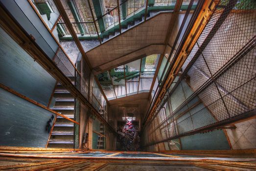 looking down an elevator shaft surrounded by stairs