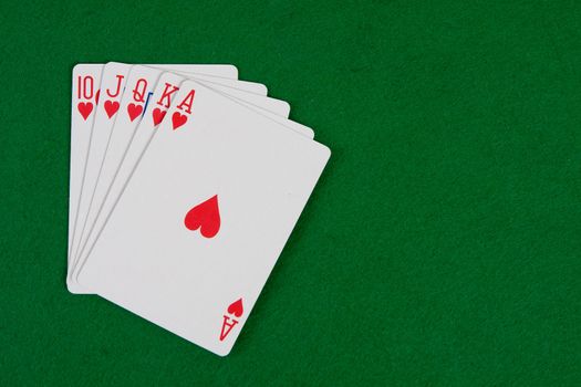 Cards with poker arrangement on green table.