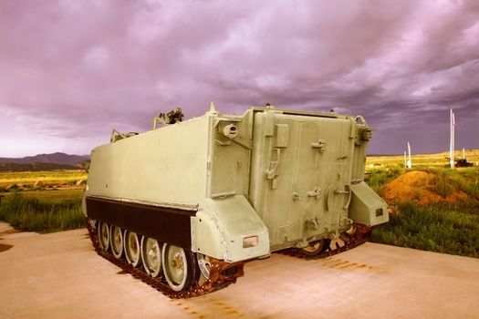 Military tank at veteran's memorial under stormy skies