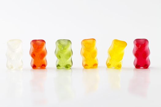 colorful row of jelly bears on white background