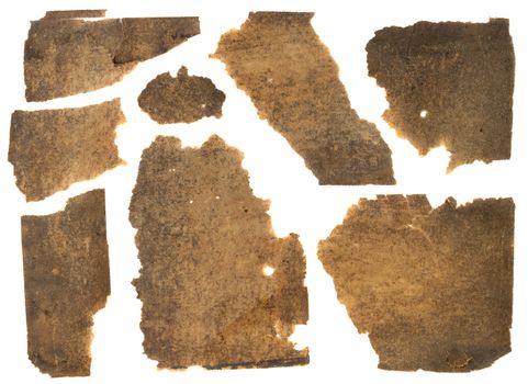 torn pieces of old thin brown paper stained with black dust, isolated on white