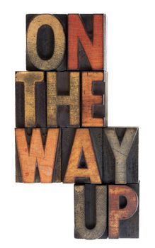 On the way up phrase in vintage letterpress wooden type, stained by ink, vertical layout, isolated on white