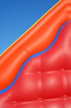 Partial view of a colorful inflatable blow-up toy on blue sky background 