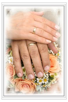 hands with wedding rings on wedding flowers