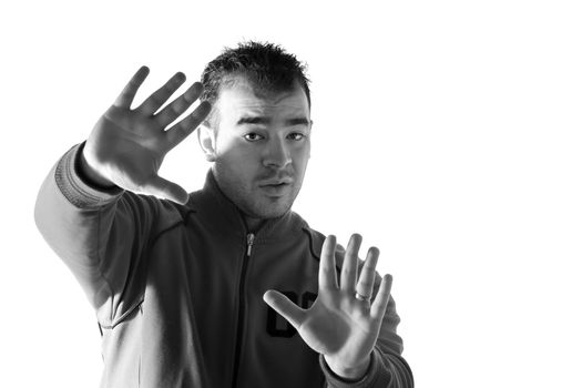 A young man holding his hands up in the air fearfully refusing or denying something.  Black and white.