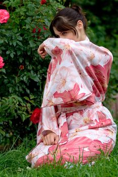 Girl in a pink yukata near rosebush
