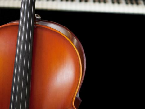 Cello standing in front on a piano