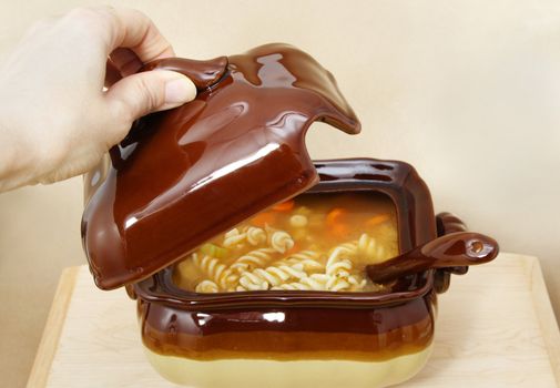 soup tureen on yellow tablecloth, beige background