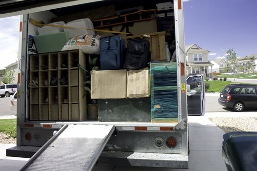 Packing up the box truck with household belongings, ready to travel and move.
