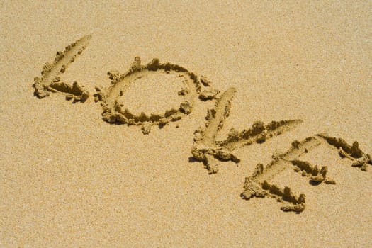Word LOVE written in sand on beach.