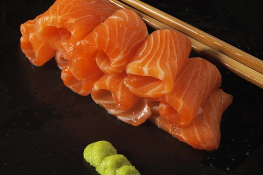 slice of salmon sushi with wasabi sauce