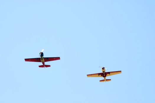 Two propeller-driven airplanes on clear sky  background
