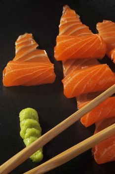 slice of salmon sushi with wasabi sauce