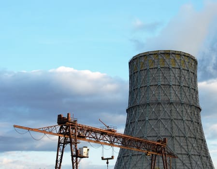 The bridge crane and cooling tower against the sky