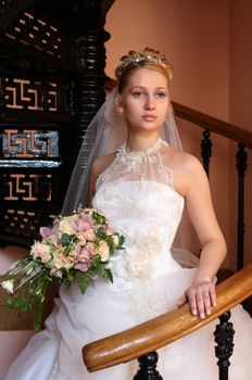 The beautiful bride with a bouquet in an interior