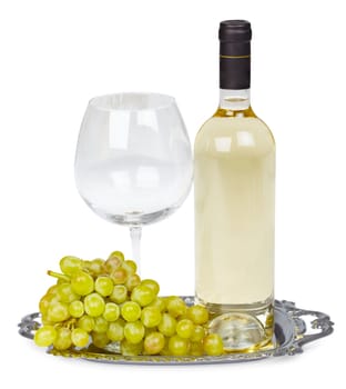 A bottle of white wine, glass and grapes on a metal tray