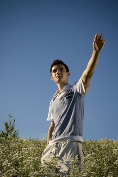 Boy among a field of daisies, with a clear blue sky as background and a peaceful atmosphere.