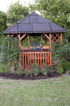wooden arbour with a roof and roses