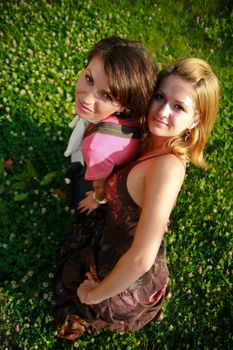 Young happy women lying on green grass, in summertime.