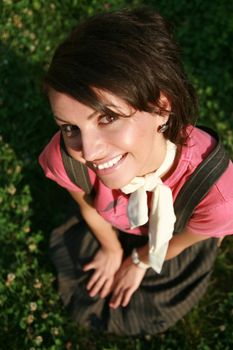 Smiling girl lying on grass in summertime.