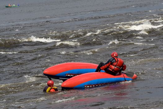 sportsmen on the upturned catamaran in the rapid 
