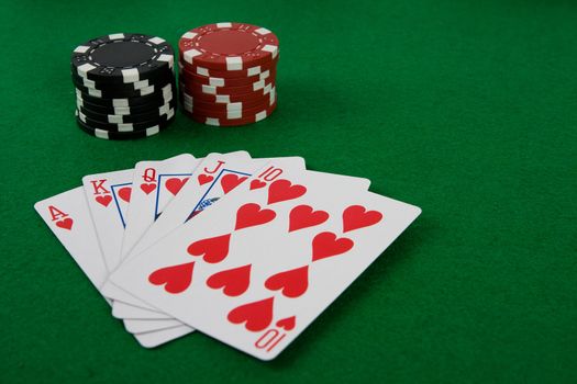 Four aces with poker chips on green poker table.