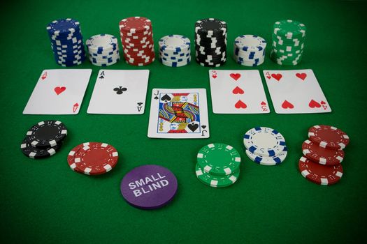 Poker set with chips and cards on the green table - small blind chip.