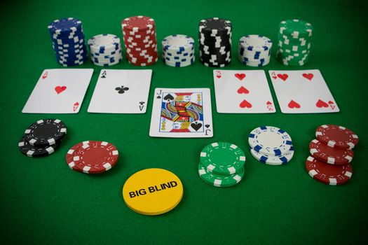 Poker set with chips and cards on the green table - big blind chip.