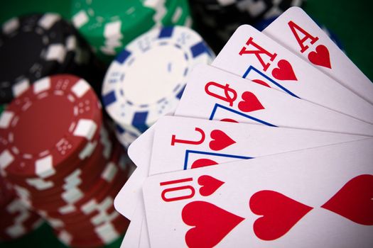 Cards with poker arrangement and poker chips in the background.