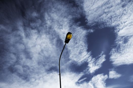 Cloudy sky with a light post in the foreground