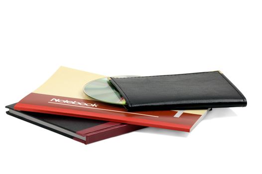 assorted notebooks with a cd flat piled on white background