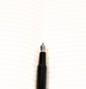 classic black fountain pen on open notebook,sepia filter