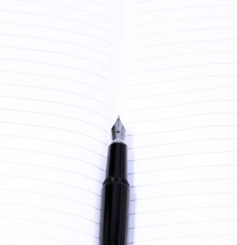 classic black fountain pen on open notebook,blue filter