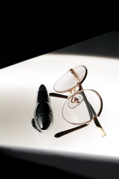 pen and glasses over white glass table