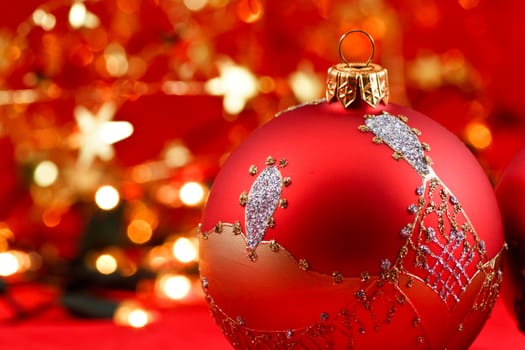 Red Christmas baubles with blurred lights in background, selective focus