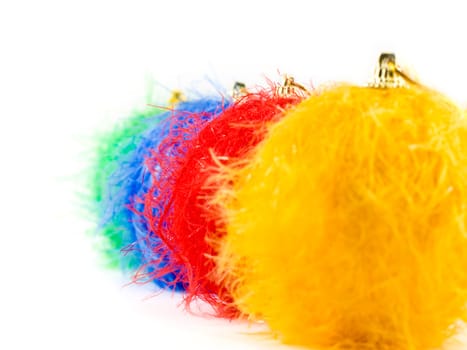 Fluffy christmas baubles on white background, focus on red bauble