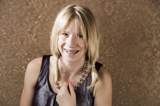 Blonde teenager with braces in a party dress