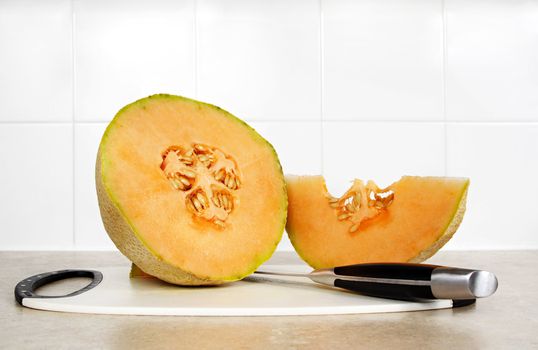 cantaloupe and knive on cutting board