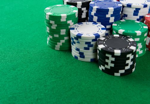 Stack of poker chips on green background.