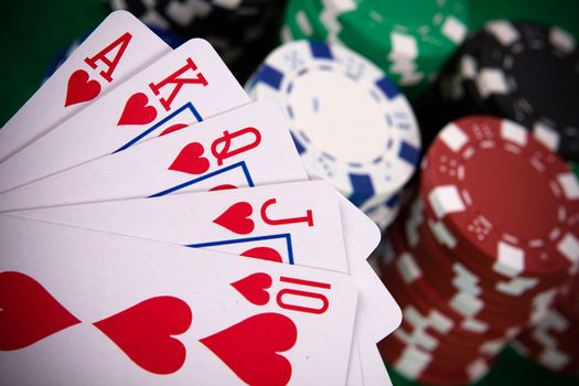 Cards with poker arrangement and poker chips in the background.