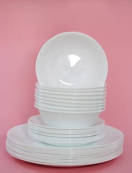 white dishes stacked, pink background 