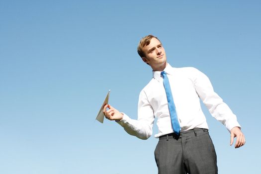 A business man throwing a paper plane